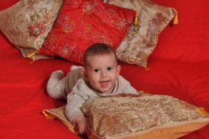 baby holding a huge pillow